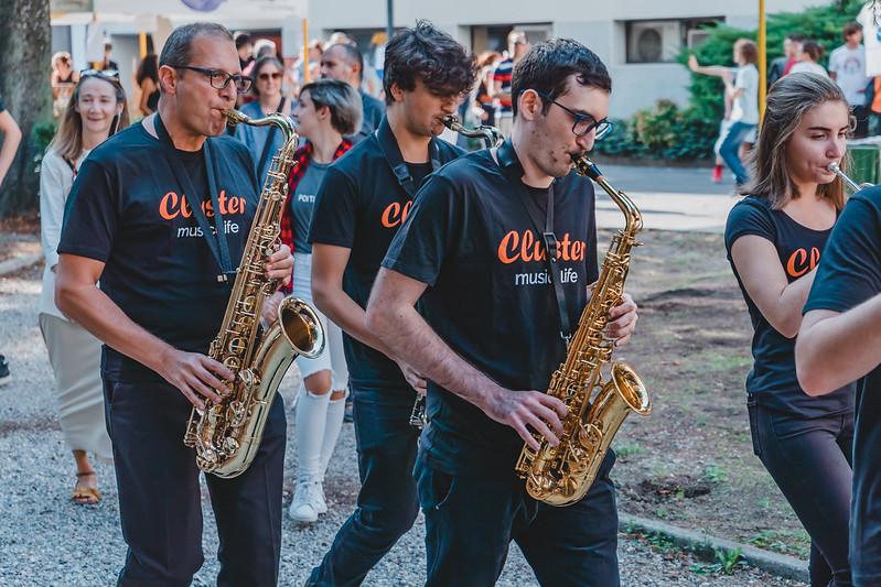 Sassofonisti che suonano e camminano